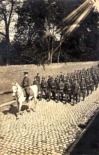 Un détachement allemand, rue Jeanne d’Arc. Derrière le mur il y a le bois Gras. Le mur existe toujours mais pas le bois qui a été remplacé par de belles maisons.
